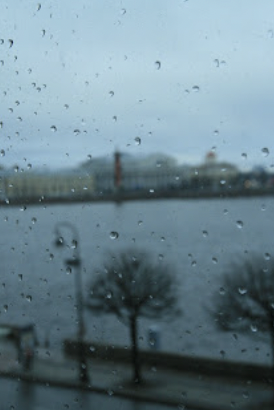 View of buildings from behind a rain-drop splattered window.